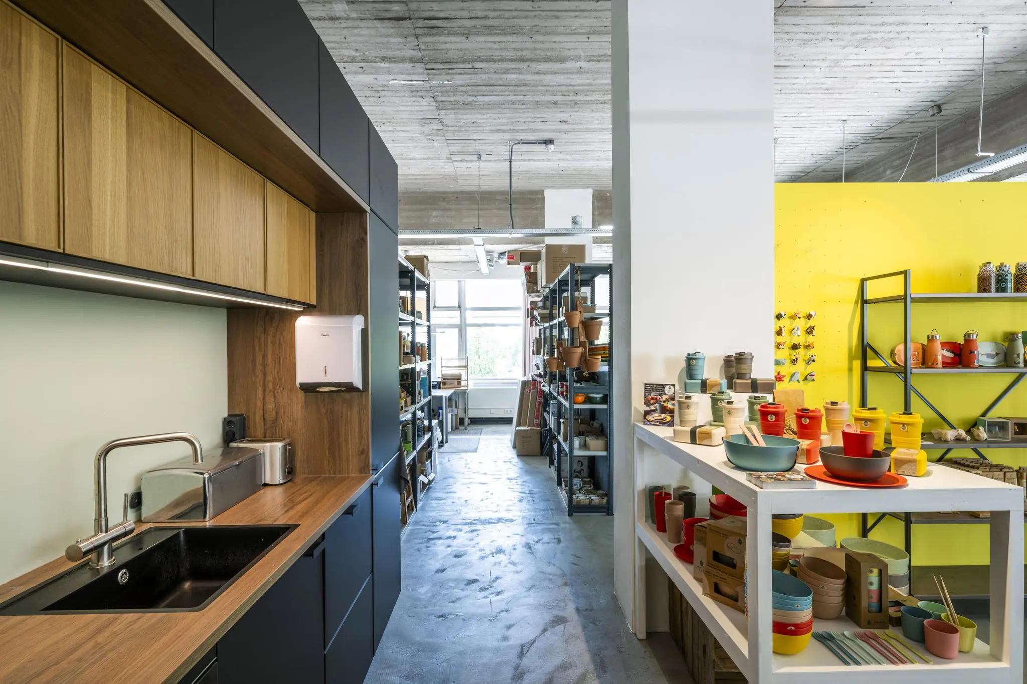 Modern ingerichte showroom aan de Van Leijenberghlaan met een keukenblok, stellingkasten en kleurrijke serviesproducten.